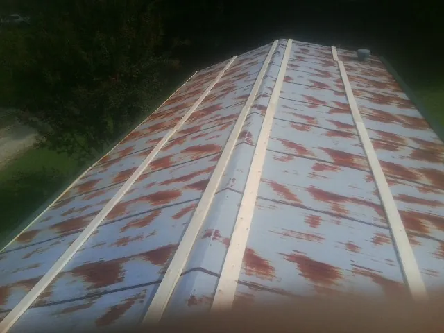 Rusted metal roof panels with new wood purlins before replacement — Storm Damage Roof Repair in Pony by Roofing Brothers